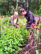 Foto van Bram die een tevreden klant van Fieflora helpt met het plukken van haar eigen bloemen